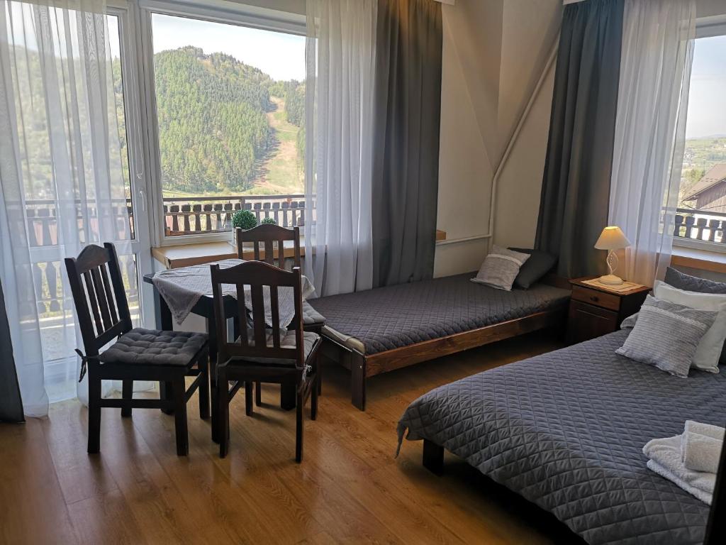 什恰夫尼察Willa Tiramisu的酒店客房带两张床和一张桌子以及椅子。