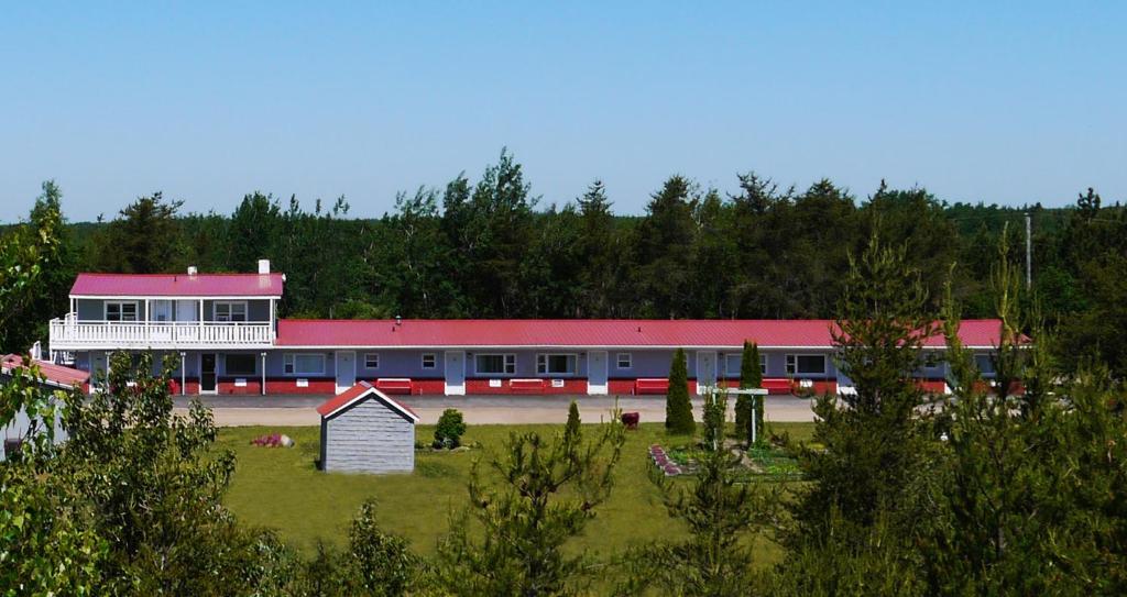 蒙克顿奥贝格雷斯特维汽车旅馆的一座有红色屋顶和田野的学校建筑