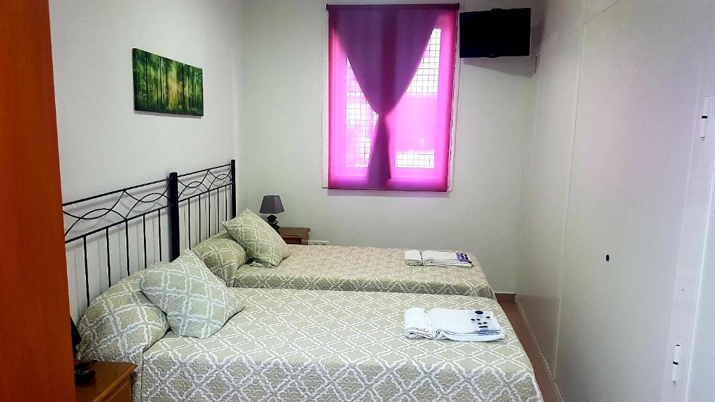 卡尔达斯·德·雷斯Apartamento Study 1 Select Real Caldas de Reis的带2张床的带粉红色窗户的客房