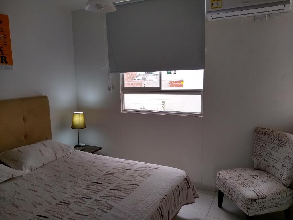 巴耶杜帕尔CH3 Moderno apartamento amoblado en condominio RNT-1O8238的一间卧室设有一张床、一个窗口和一把椅子