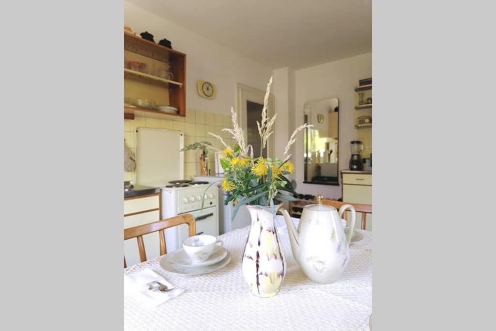 霍恩埃姆斯Dimai House 1950s的厨房配有一张桌子,上面有两瓶花