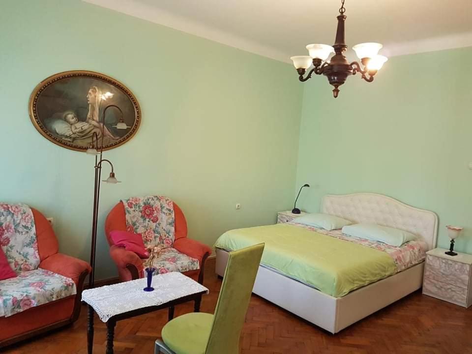 里耶卡Soba Marinko的一间卧室配有一张床、两把椅子和一张桌子