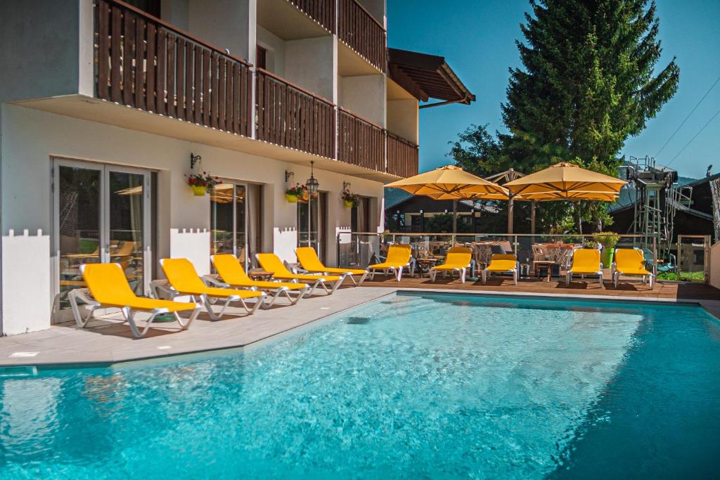 贝勒沃克里斯塔尼亚酒店的游泳池配有黄色椅子和遮阳伞