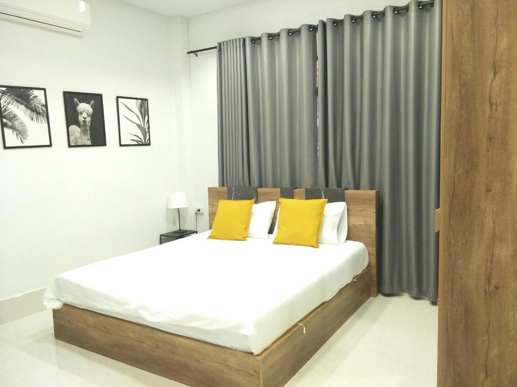 勿洞Betong Cozy Guesthouse เบตง โคซี่ เกสต์เฮาส์的一间卧室配有一张带黄色枕头的大床
