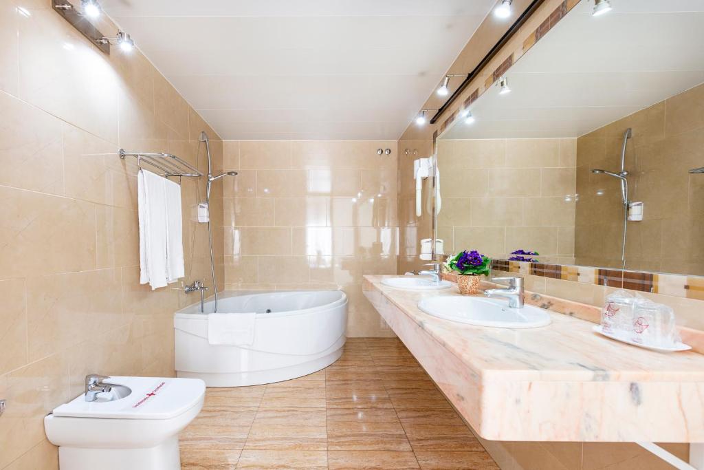 巴塞罗那拉莫斯旅馆的一间带两个盥洗盆、浴缸和卫生间的浴室