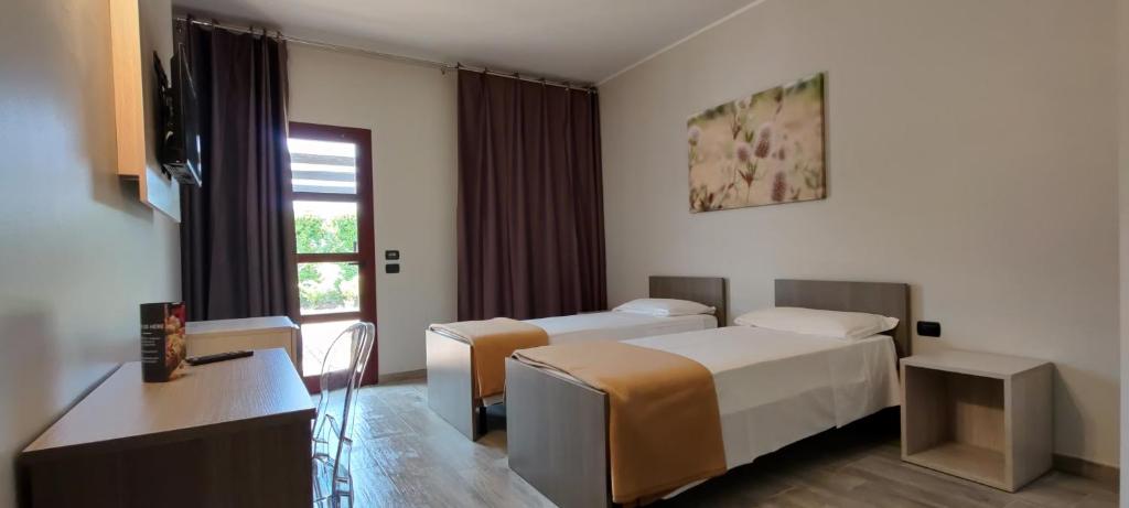 欧皮达托洛迪金Break Hotel的酒店客房设有两张床和窗户。