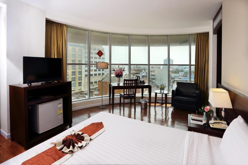 合艾金皇上豪大饭店的酒店客房设有床和客厅。