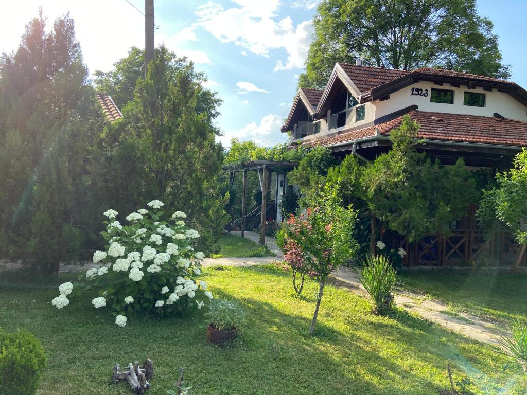 阿普里尔齐Вилно селище Паздерите的前面有白色花的院子的房子