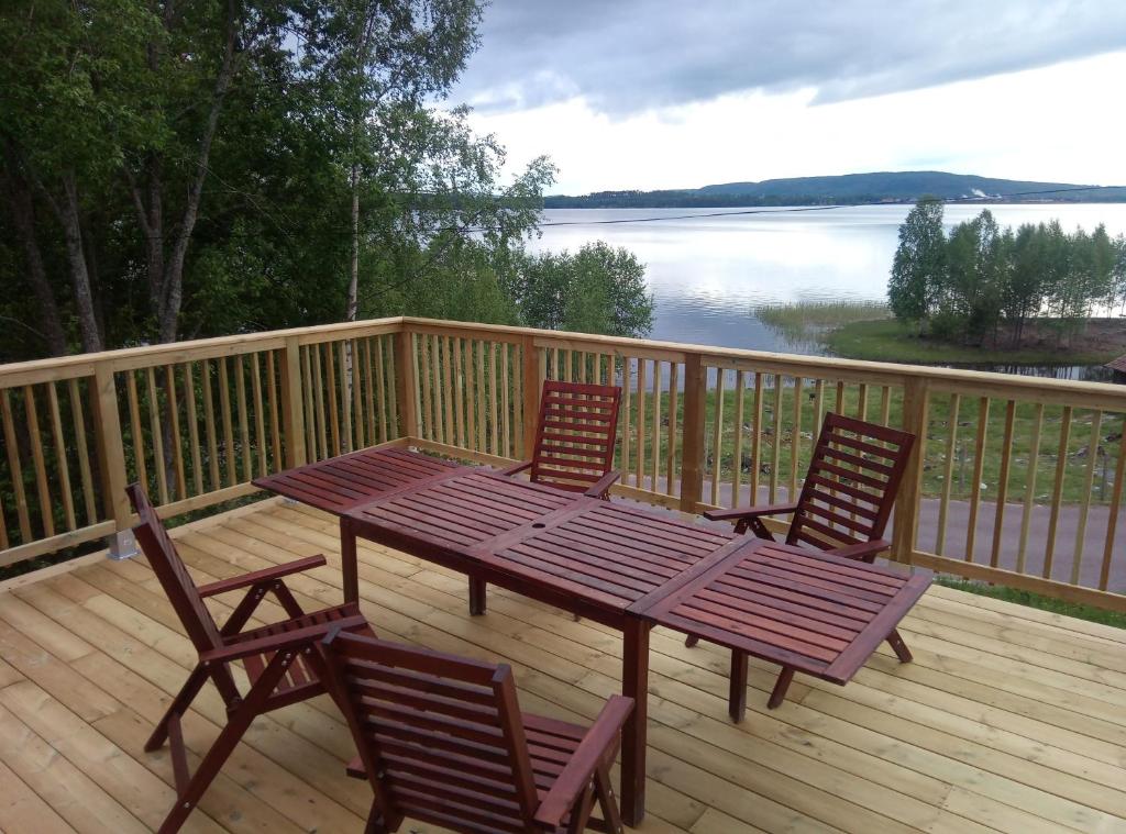 雷克桑德Dimgården的木制甲板配有野餐桌和两把椅子