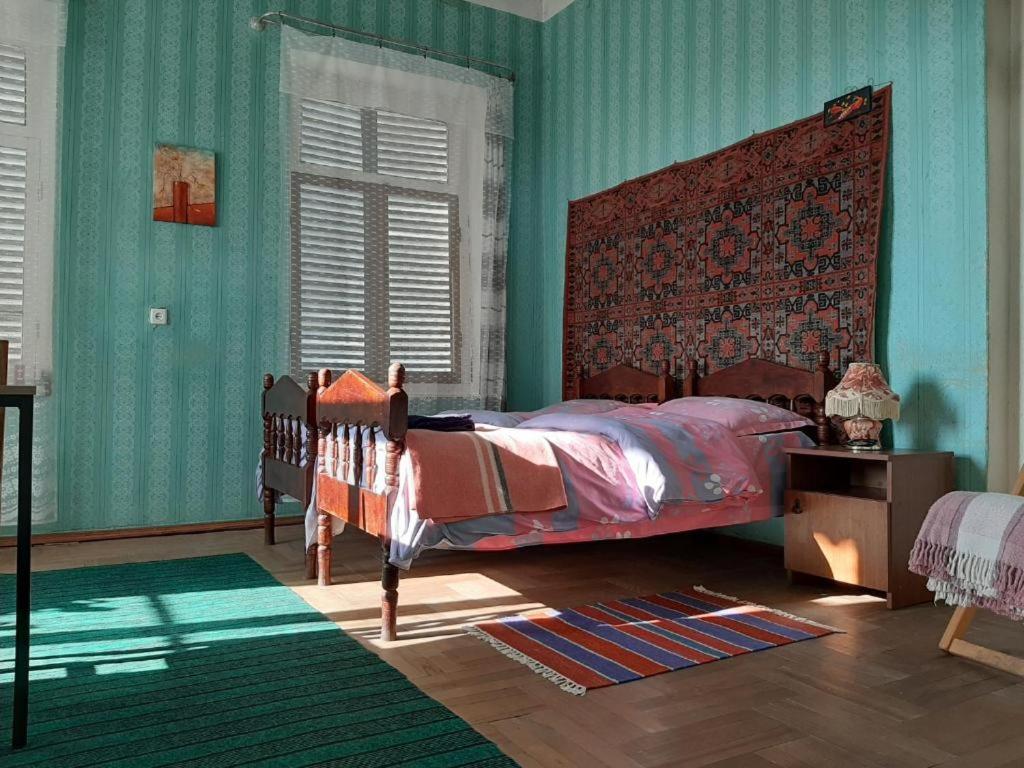 泰拉维Cabernet Tali的一间卧室设有绿色的墙壁和一张红色床头板的床