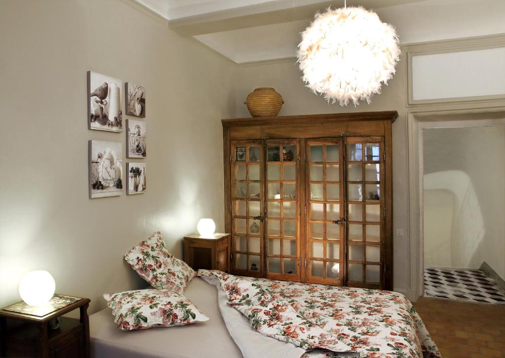 尼翁Maison de Maître Des-Sens的一间卧室配有一张床和一个吊灯