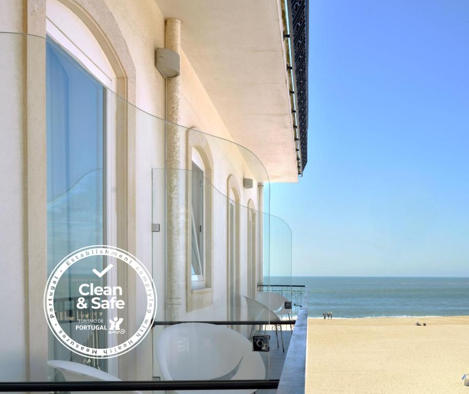 纳扎雷马尔布拉沃酒店的海滩景公寓大楼设有桌椅