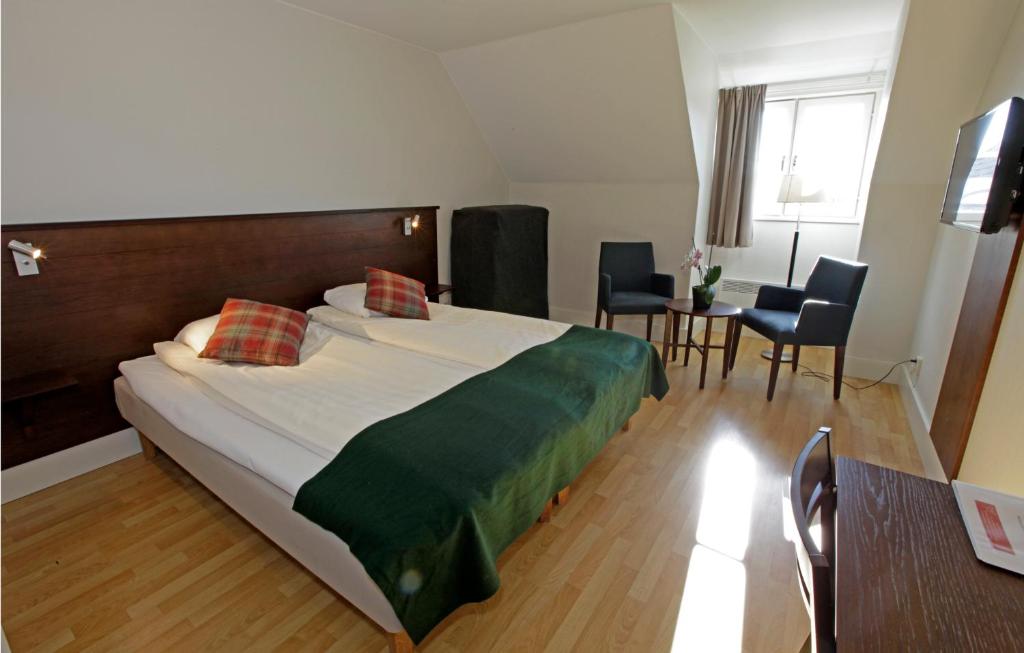卡尔马卡尔马拉斯塔酒店的一间卧室配有一张大床和一张桌子及椅子