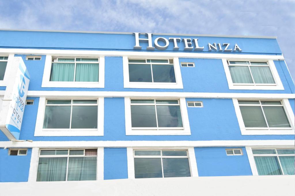 莱昂Hotel Niza Zona Piel的蓝色的建筑,上面有酒店nza标志