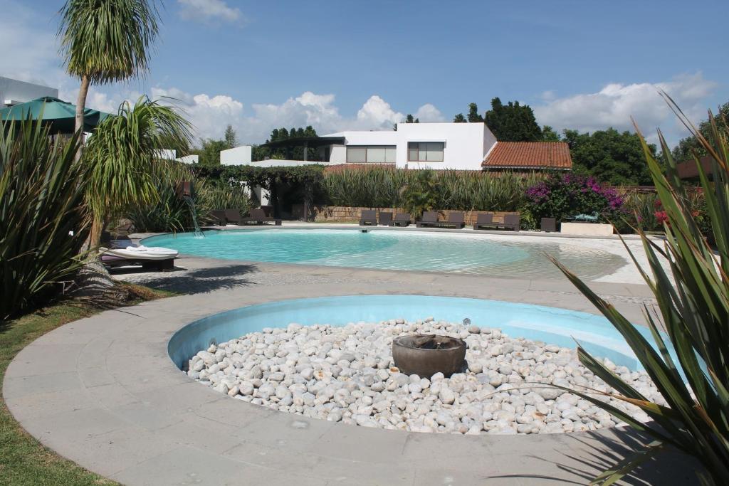 阿特利斯科Hotel & Spa Luna Canela Boutique的庭院内一个带岩石火坑的游泳池