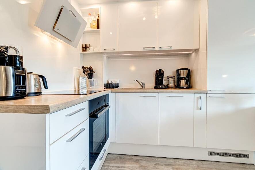 斯维诺乌伊希切White Apartment Swinemünde的白色的厨房配有白色橱柜和电器