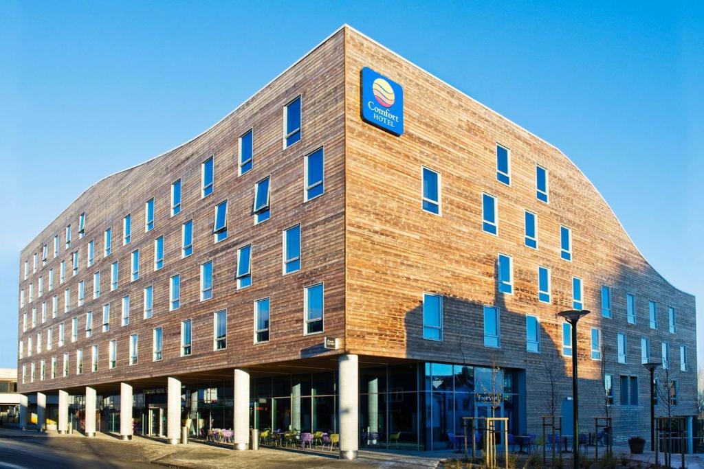 斯塔万格康福特茵酒店的一座大砖砌建筑,上面有蓝色标志