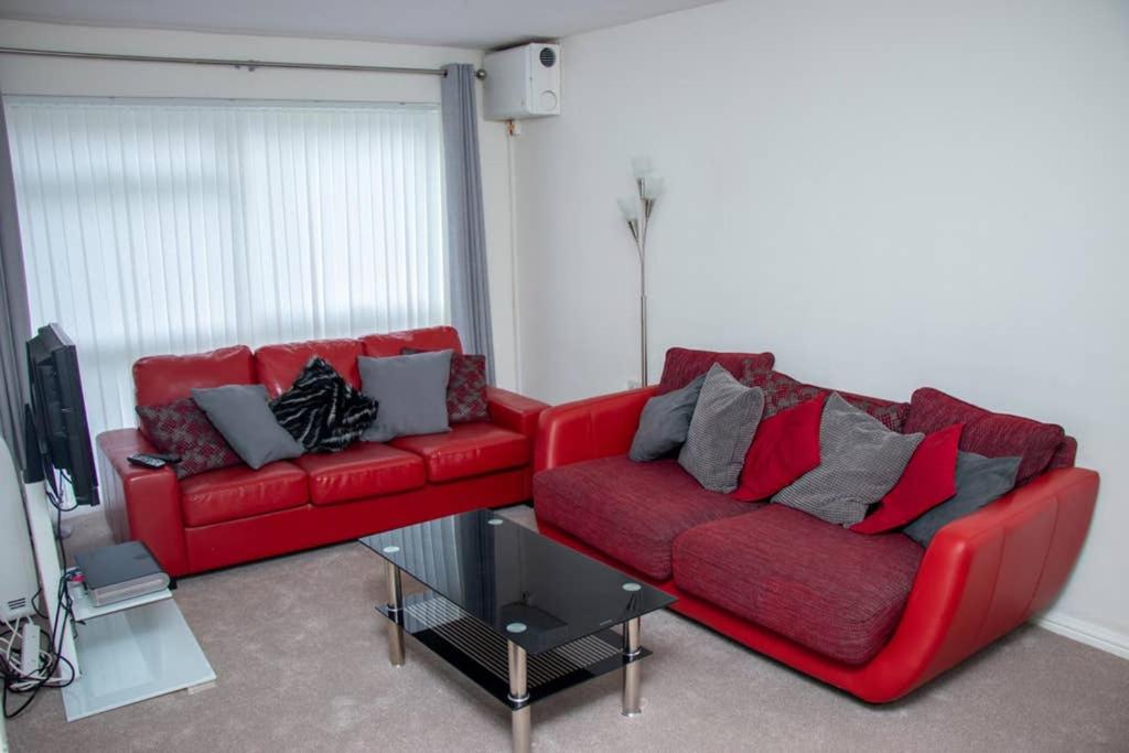 克劳利Crawley Apartment near Gatwick Manor Royal Newly Refurbished Sleeps 4的客厅配有2张红色沙发和电视