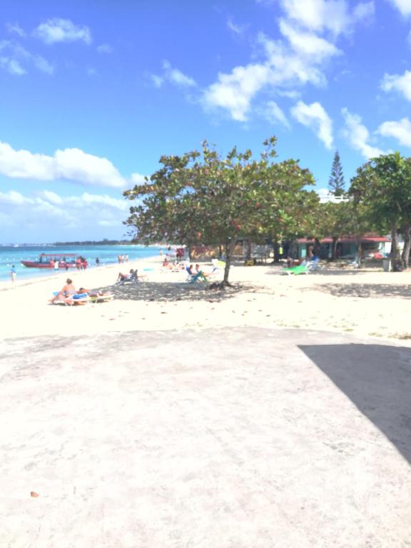 尼格瑞尔Negril Beach Club Condos的一群人坐在海滩上