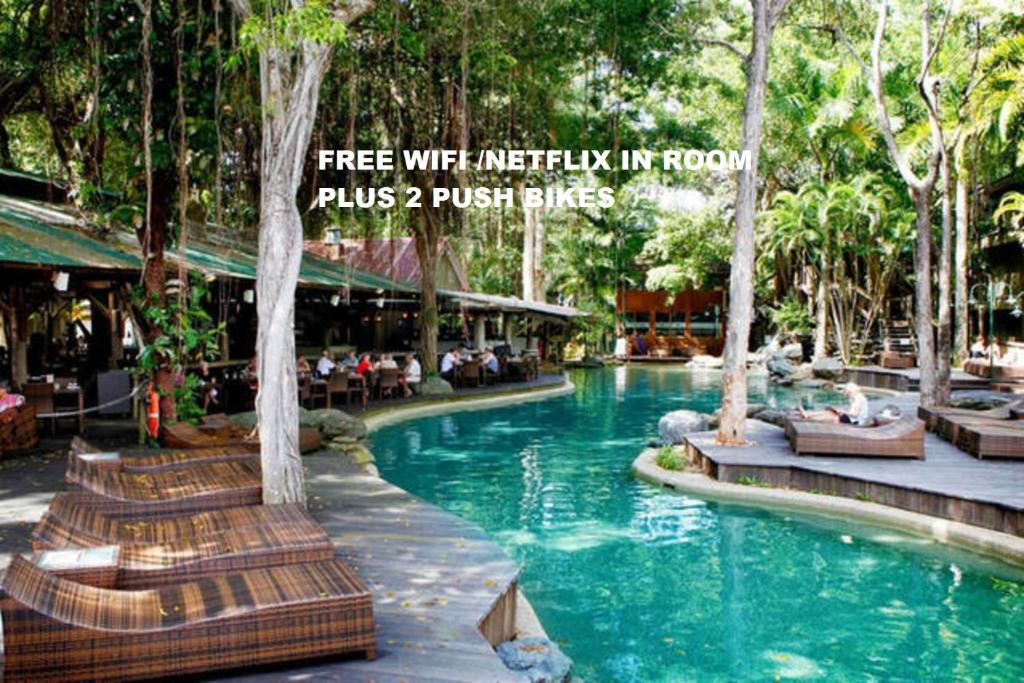 道格拉斯港Sonia's At Ramada Resort Free Wifi & Netflix的度假村的游泳池,人们坐在椅子上