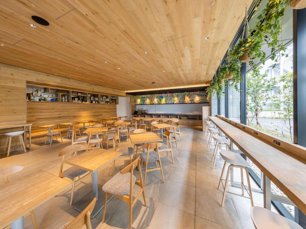 东京Far East Village Hotel Tokyo Ariake的餐厅设有木制天花板和桌椅