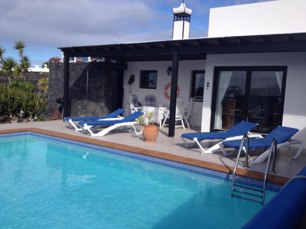 普拉亚布兰卡Villa Burgao的一个带椅子的游泳池以及一座房子
