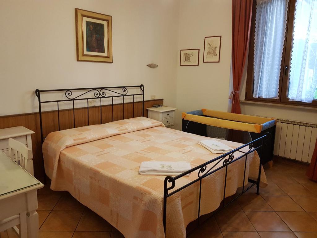 佛罗伦萨阿尔伯格索尼亚酒店的一间卧室配有一张床、一张桌子和一个窗户。