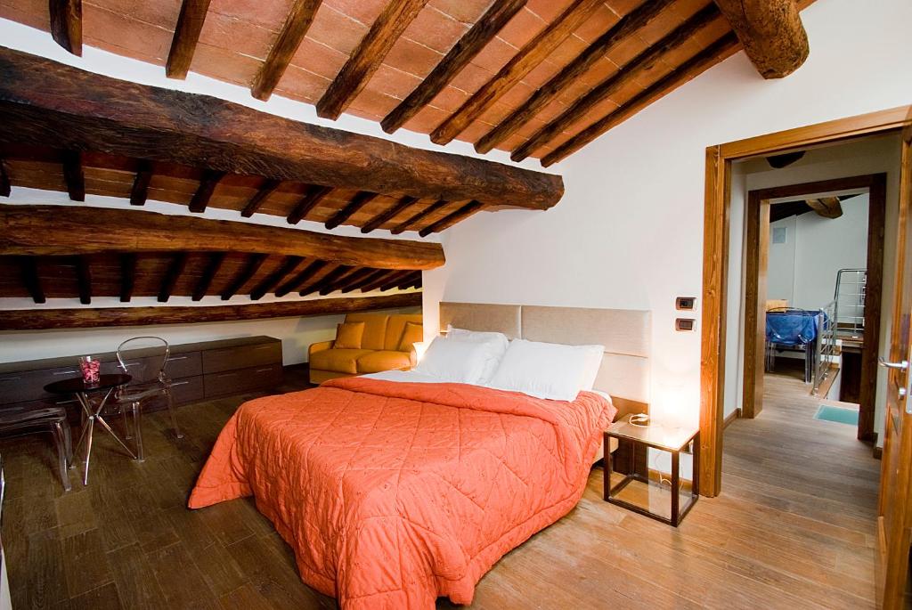 蒙特普齐亚诺维可罗德洛斯特酒店的一间卧室配有一张带橙色棉被的床
