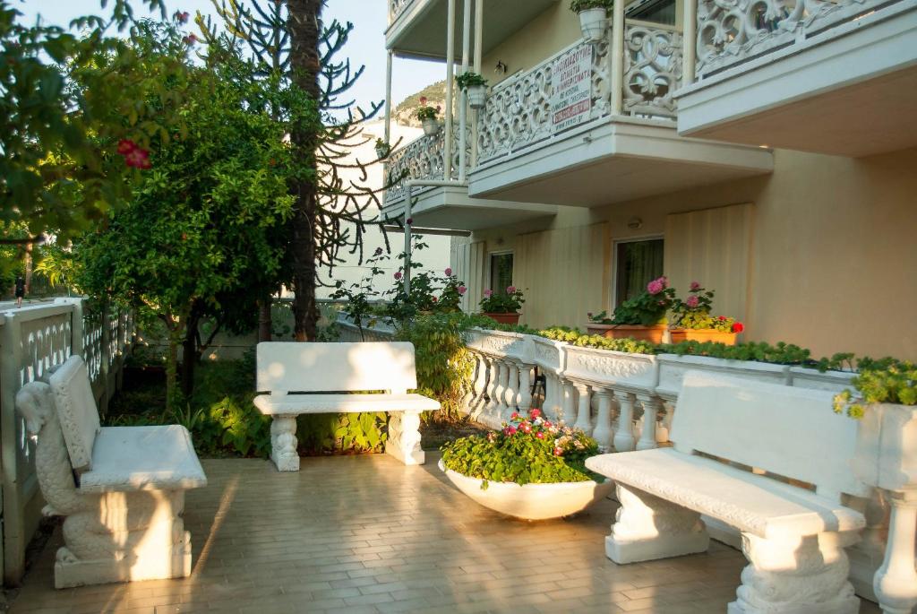 卡梅纳维洛拉RONZI APARTMANT的一座庭院,里面设有白色长椅和鲜花