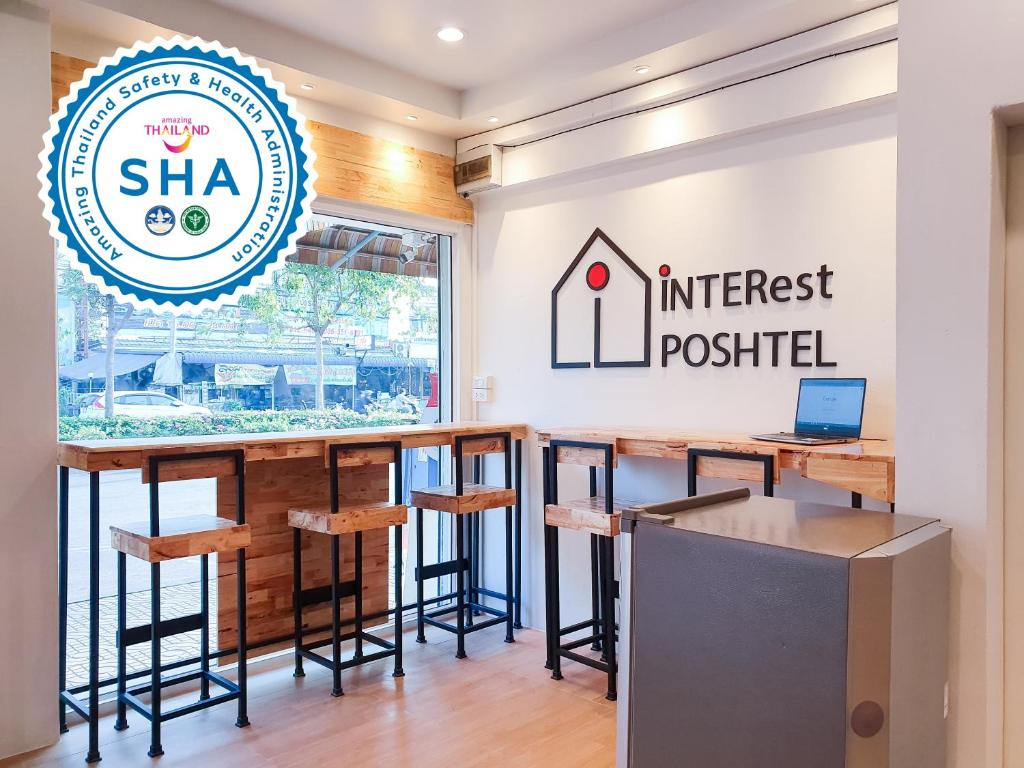 曼谷INTERest POSHTEL的酒吧,有凳子和贴有利息标志