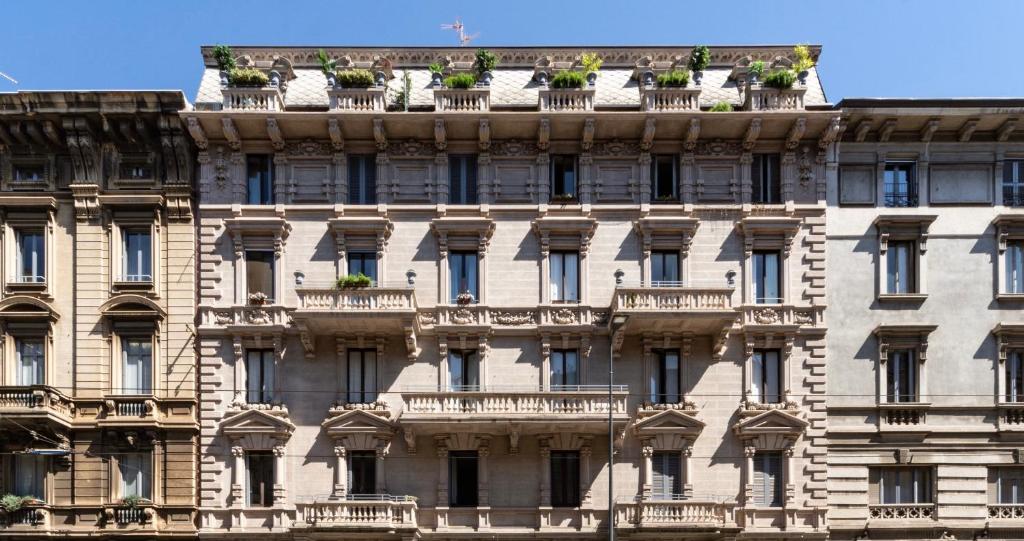 米兰Le Dimore Suites Milano的屋顶上种植盆栽植物的公寓楼
