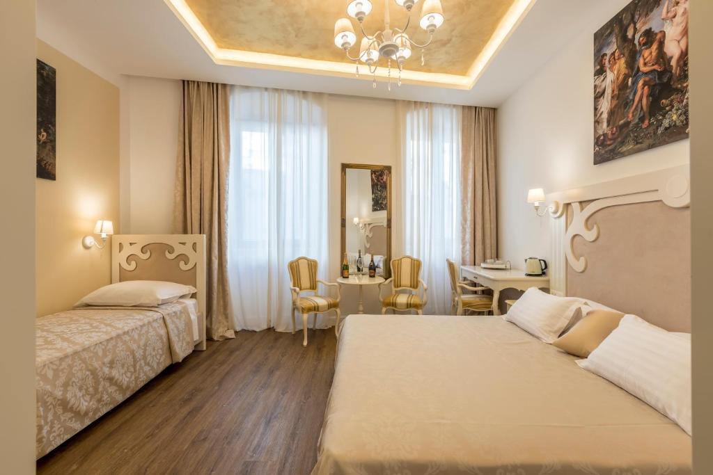 斯普利特Palace of Dreams Rooms的酒店客房设有两张床和用餐区。