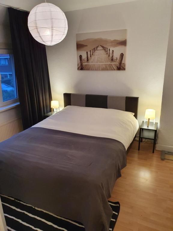 鹿特丹Single family home in Hillegersberg - Schiebroek的一间卧室配有一张大床和两盏灯。