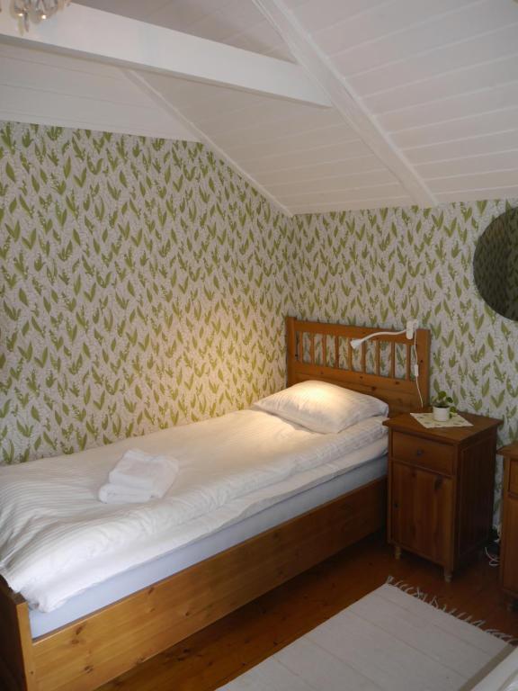 恩厄尔霍尔姆Havsnära 1700-tals Timmerstuga的一间卧室配有一张床和一张桌子及床头柜