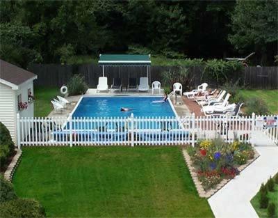 威尔斯天桥北酒店的一个带白色围栏和椅子的游泳池