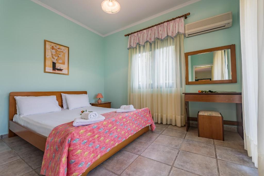 阿克罗蒂Small Village Residences的一间卧室配有一张带镜子的床和一张书桌