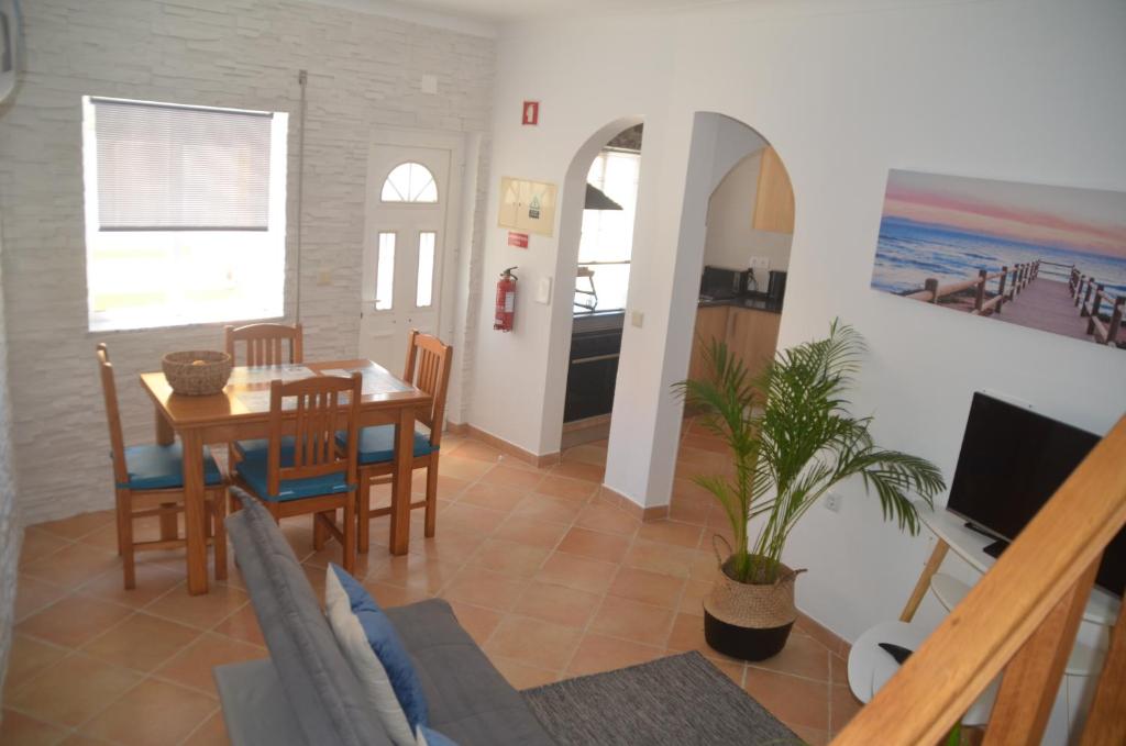 维拉多比斯坡Casa Flora T1 - Vila do Bispo的用餐室以及带桌椅的起居室。