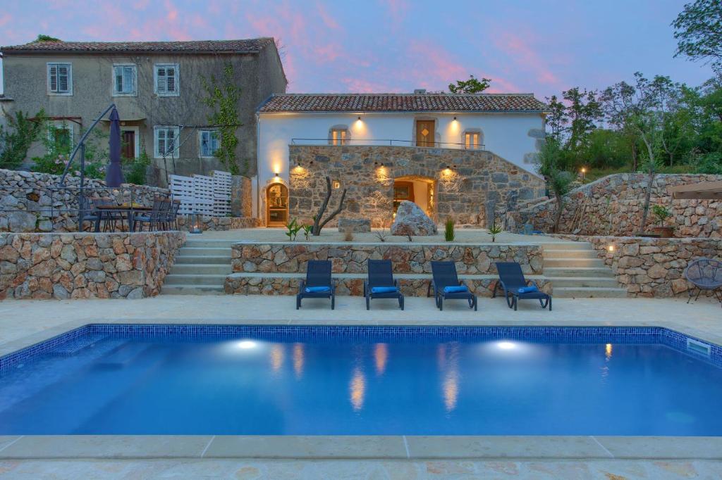 戈斯蒂加卡Villa MAY的房屋前有游泳池的房子