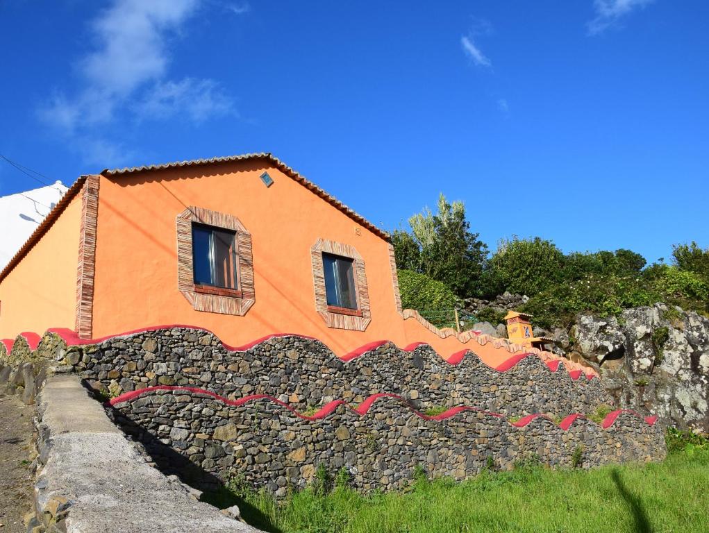 Lajes das FloresCasa Boa Onda的石墙顶上的橙色房子