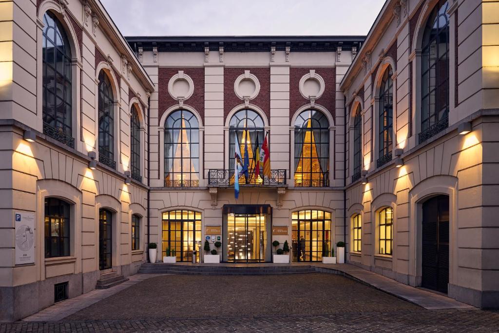 列日Van Der Valk Sélys Liège Hotel & Spa的一座大型建筑,有许多窗户和灯