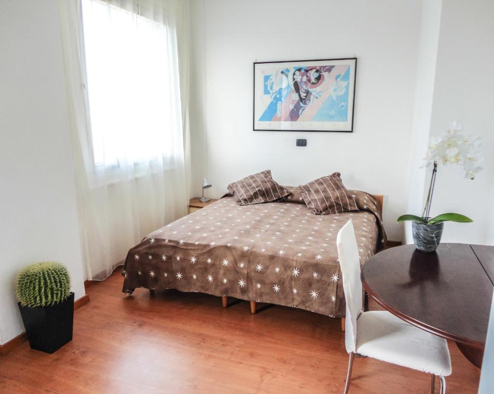 费拉拉阿罗吉奥凯沃尔酒店的一间卧室配有一张床、一张桌子和一个窗户。