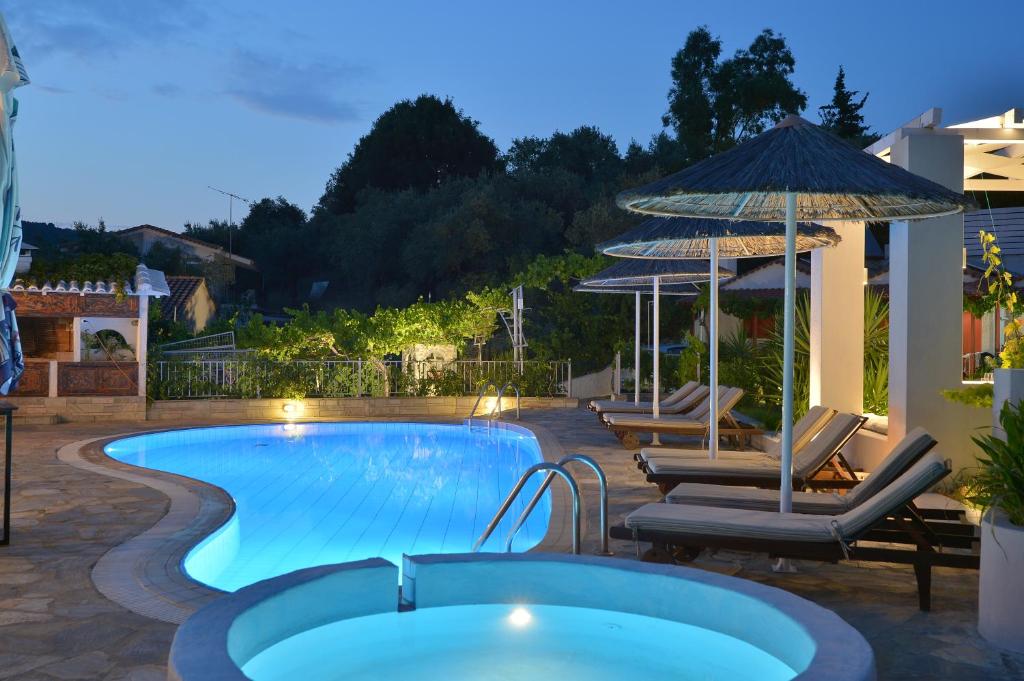 斯基亚索斯镇艾尔莎酒店的一个带椅子和遮阳伞的游泳池
