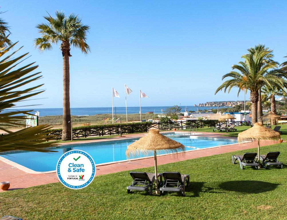 拉戈斯拉各斯伯多禄酒店的一个带椅子和遮阳伞的游泳池以及大海