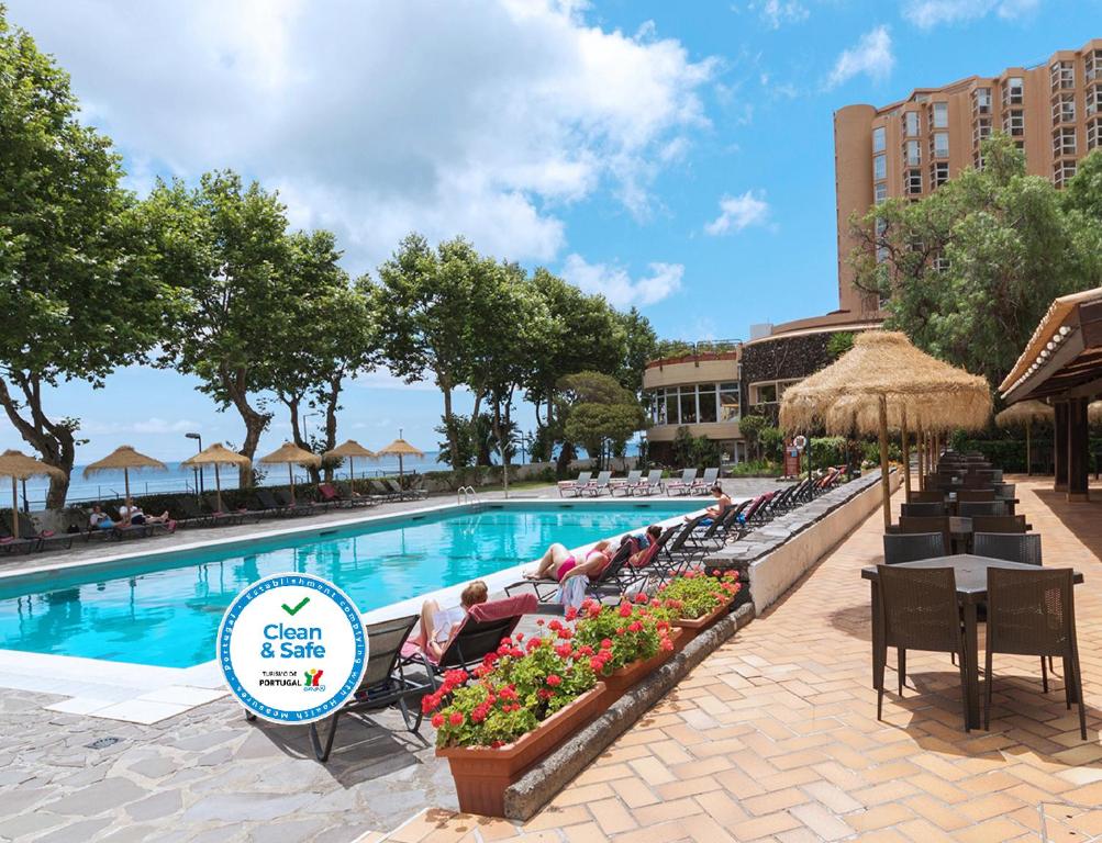 马希库多姆佩德罗马德拉酒店的一个带躺椅的度假村的游泳池以及酒店