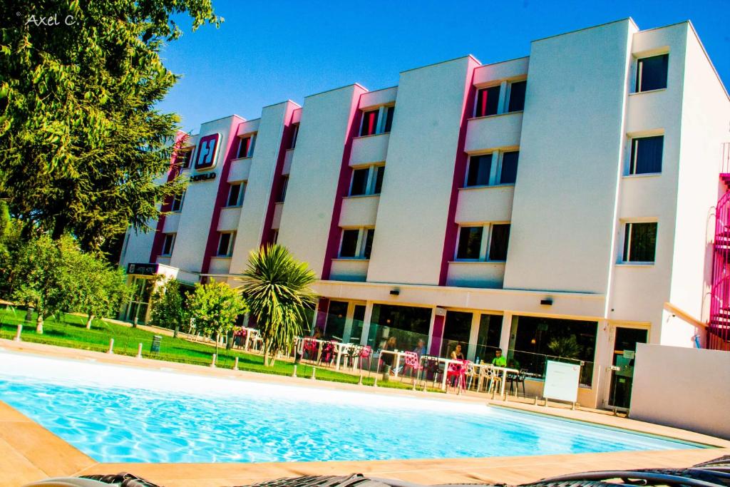 蒙彼利埃Best Western Hotelio Montpellier Sud的大楼前设有游泳池的酒店
