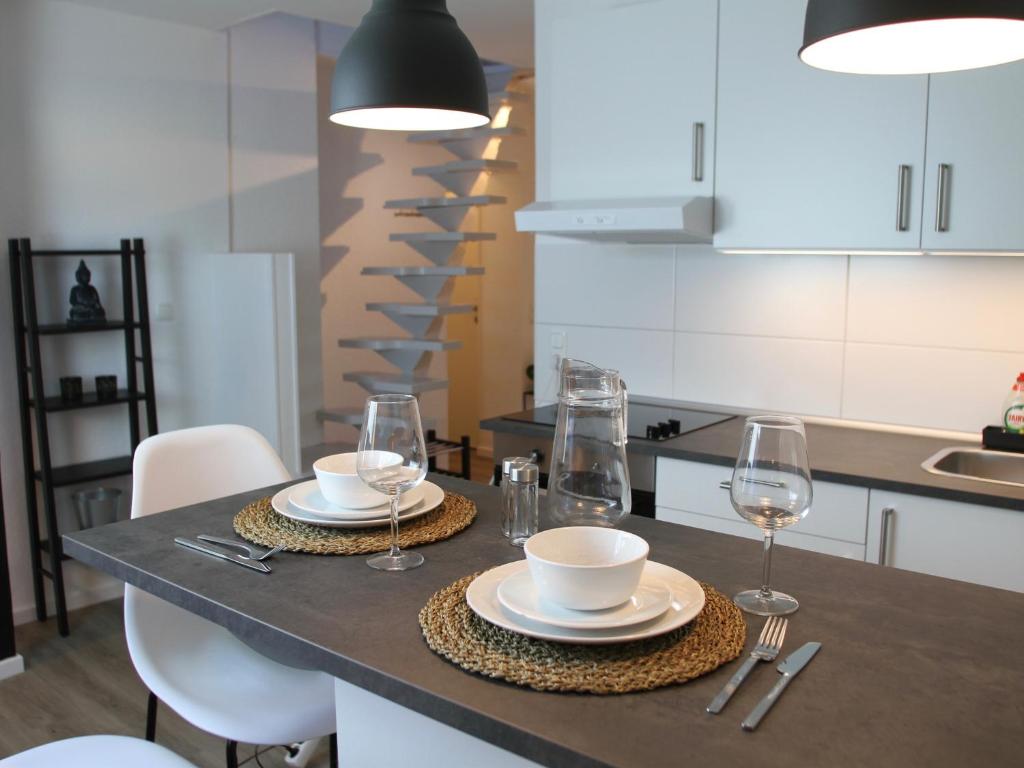 波鸿Apartmenthaus in der Arnoldstraße的厨房配有带盘子和酒杯的桌子