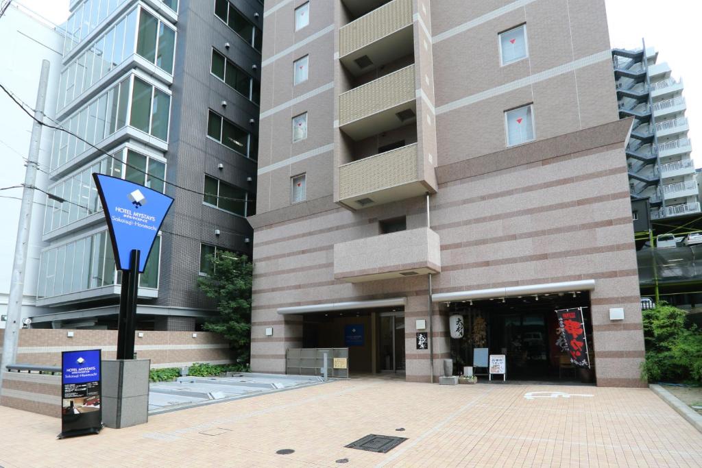 大阪MYSTAYS 堺筋本町酒店的前面有蓝色标志的建筑