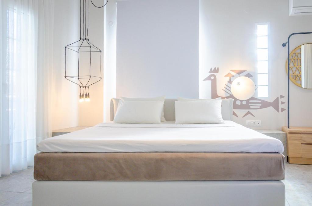 萨索斯伊格酒店的一间卧室配有一张带白色床单的大床