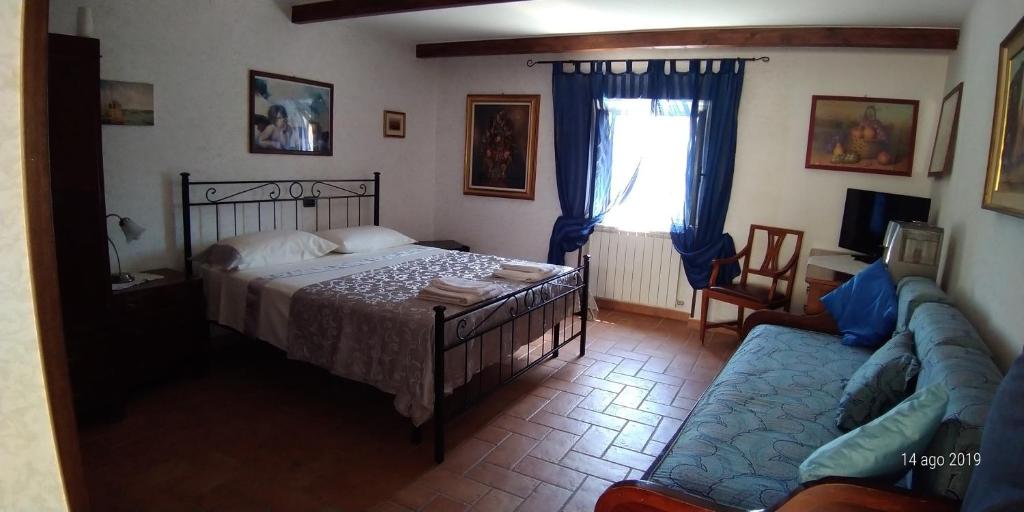 ScapoliIl Borgo 38的一间卧室配有一张床、一张沙发和一个窗口