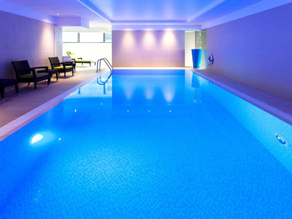 伦敦诺富特伦敦帕丁顿酒店的客房内的大型游泳池,有蓝色的水